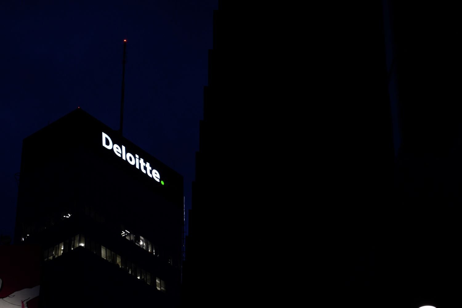A building with the Deloitte logo at night