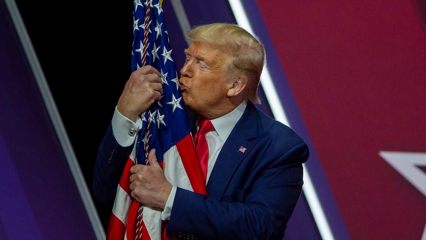 President Donald Trump kisses the flag of the United States of America at the annual Conservative Political Action Conference (CPAC) at Gaylord National Resort & Convention Center February 29, 2020 in National Harbor, Maryland.